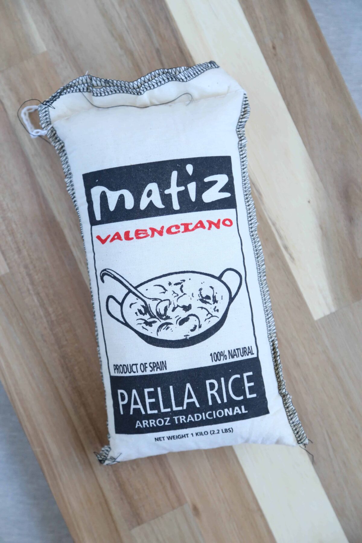 bag of matiz paella rice on a wooden cutting board.