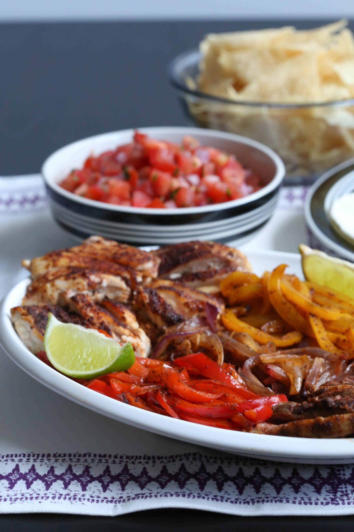 platter of chicken fajita ingredients with a side bowl of pico de gallo