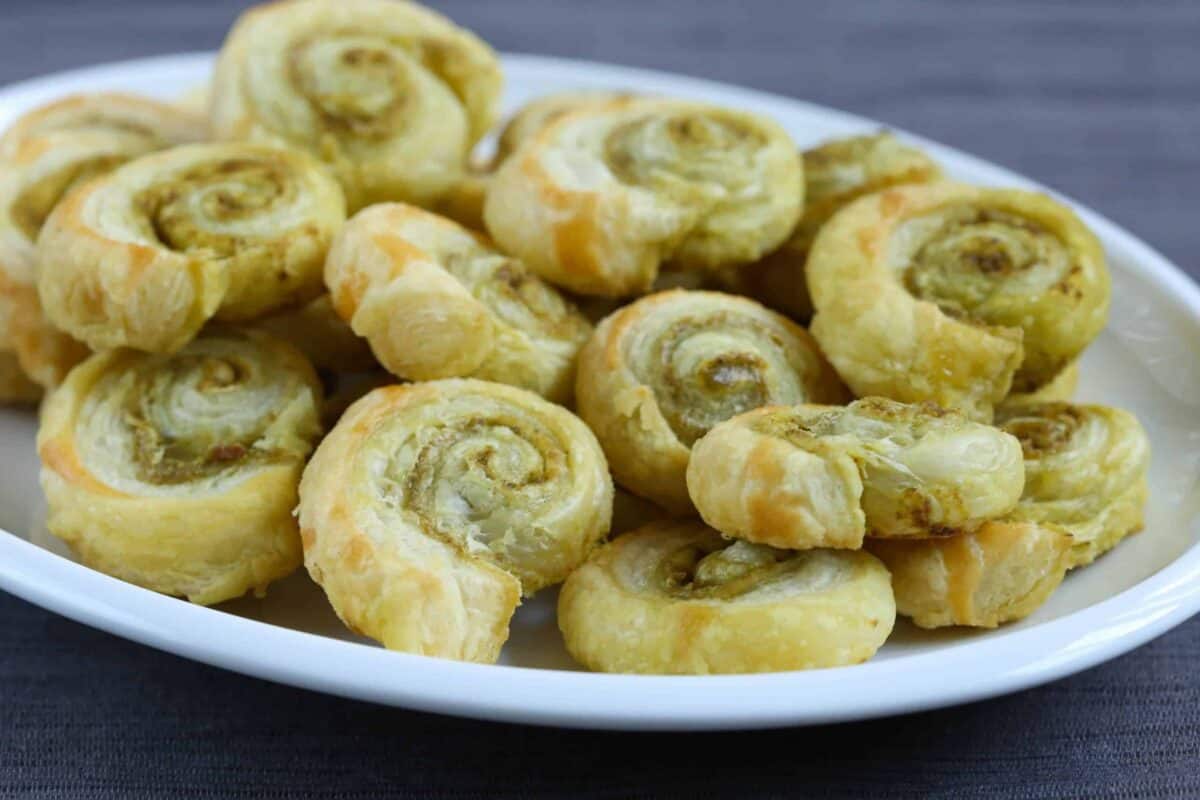 pesto pinwheels on a white platter.