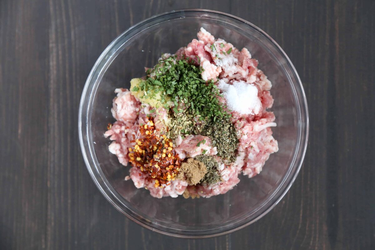 bowl of raw sausage with seasonings.