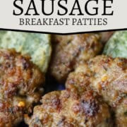 fried sausage patties lined up on a blue platter with fried sage leaves.