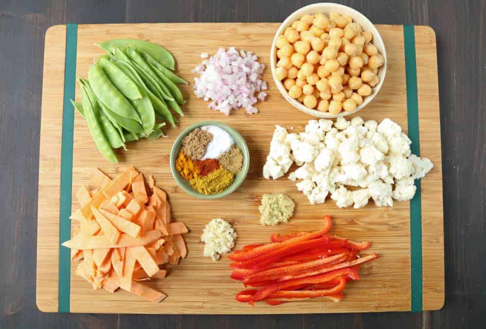 ingredients for vegetarian curry on a wooden cutting board.