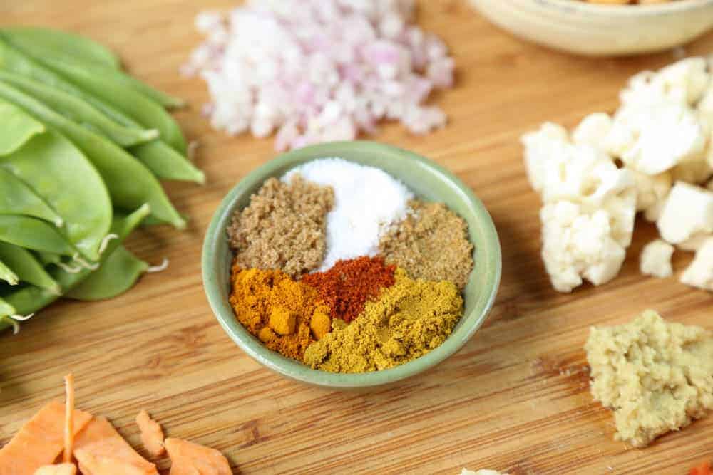 pinch bowl filled with spices on a wooden cutting board.