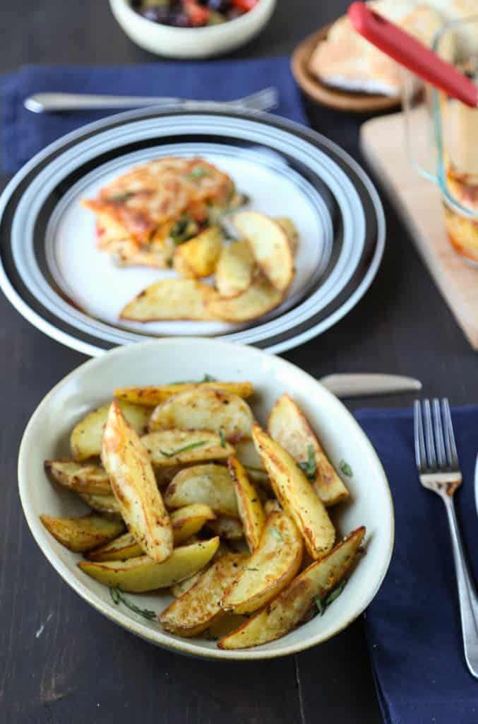 table set for dinner with lasagna and crispy garlic potatoes.