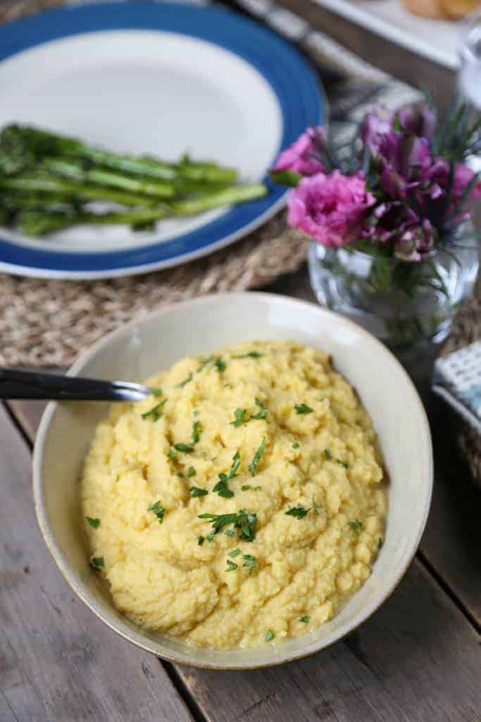 cauliflower mash in a cream bowl on a wooden table.