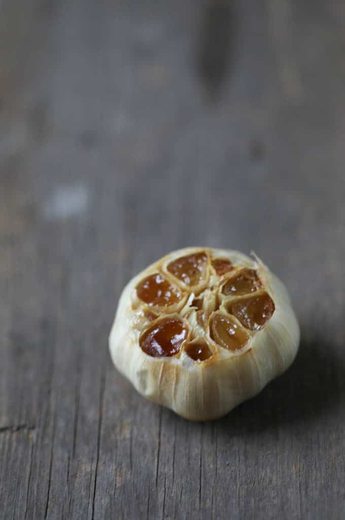head of roasted garlic on a wooden table.