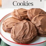 chocolate drop cookies on a white and red pedestal plate.