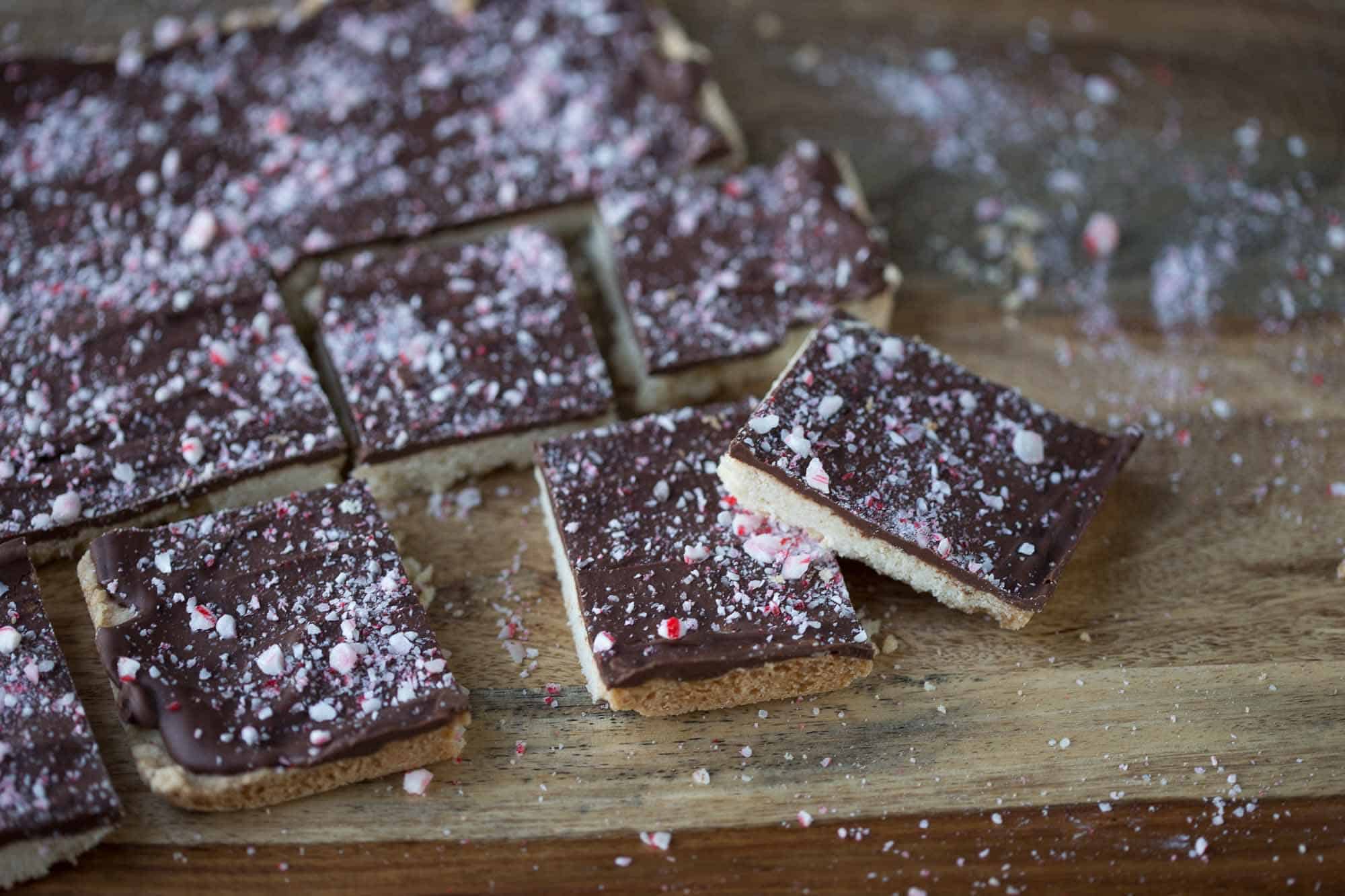 chocolate peppermint shortbread squares on a wooden cutting board.