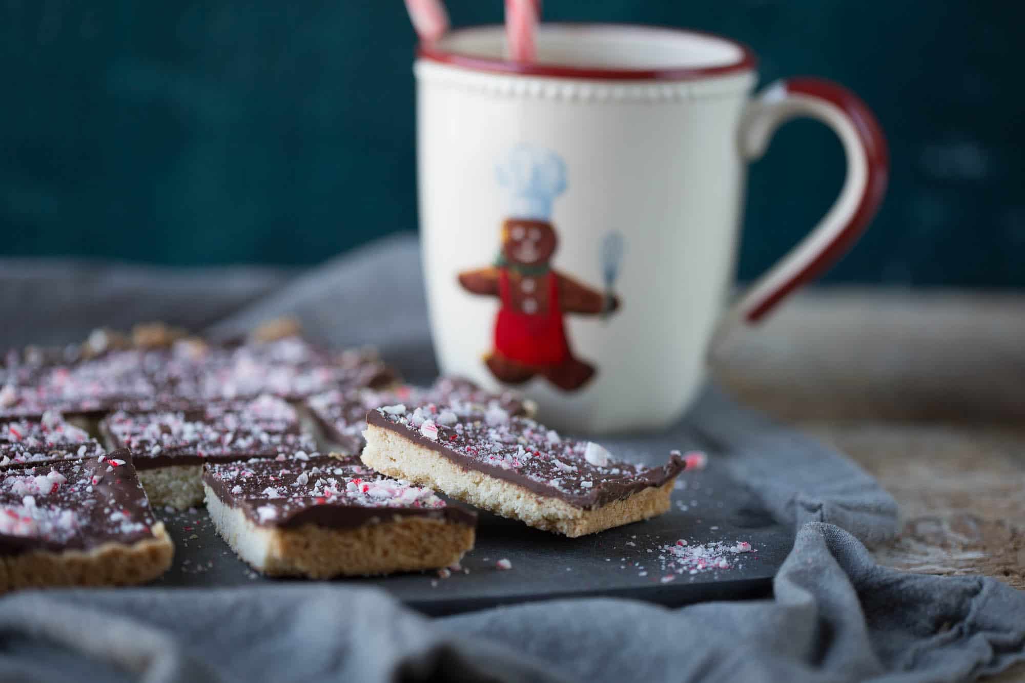 chocolate peppermint shortbread squares with a mug of hot chocolate.
