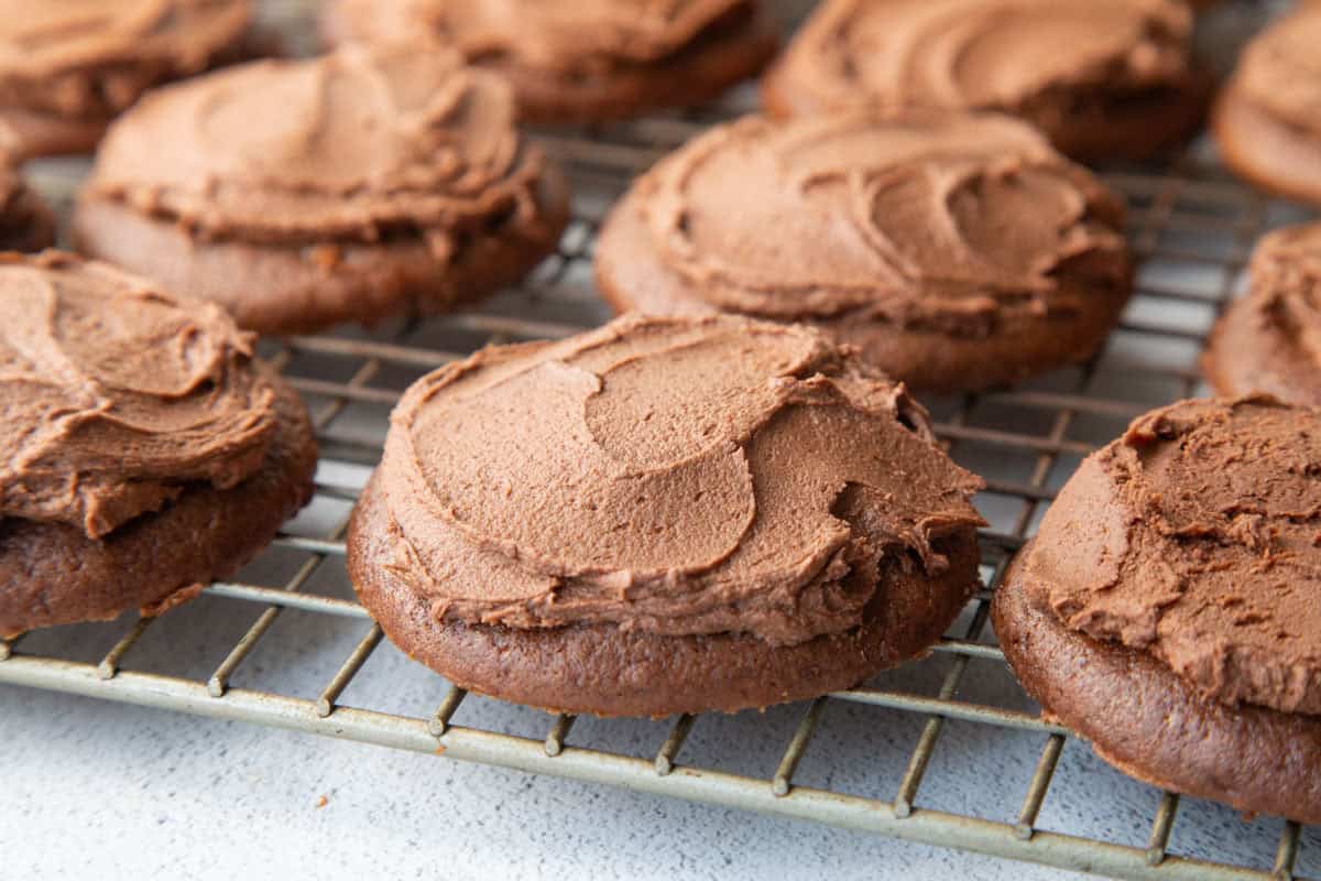 chocolate drop cookies with frosting on a wire rack.