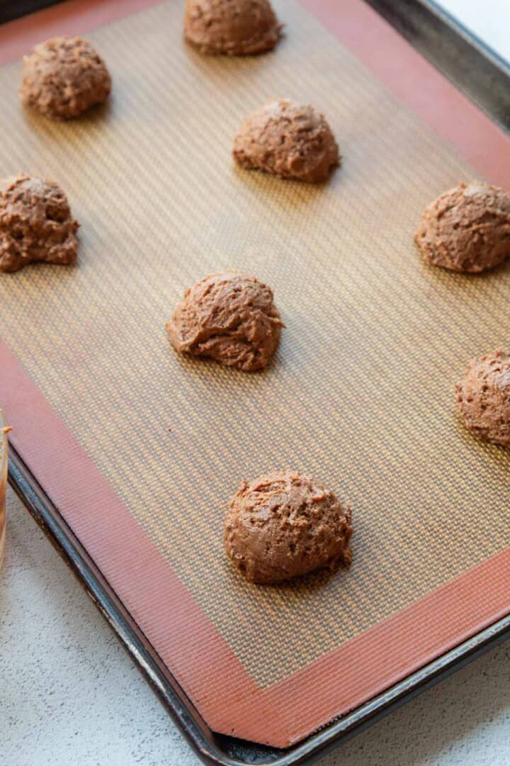 chocolate cookie dough drops on a baking sheet.