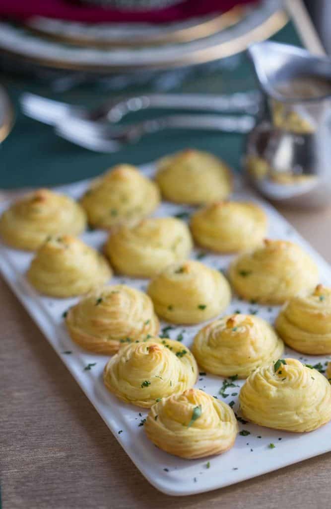 duchess potatoes on a white rectangular platter.