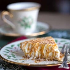 slice of eggnog pie covered in caramel sauce on a Christmas china plate.