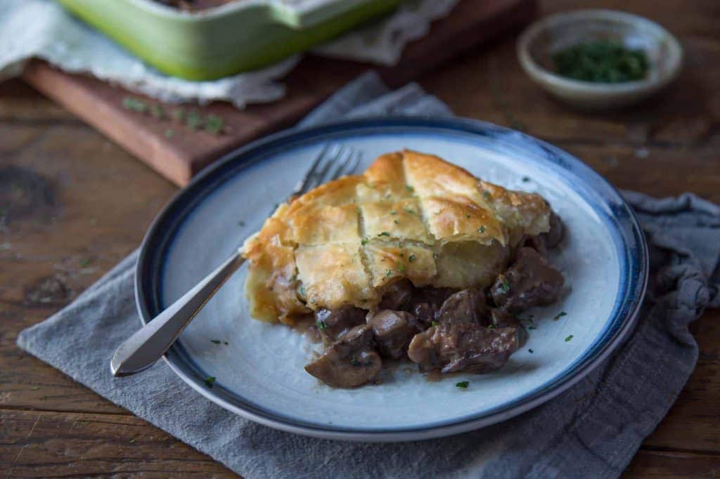 Slice of beef wellington pot pie on a plate with a fork