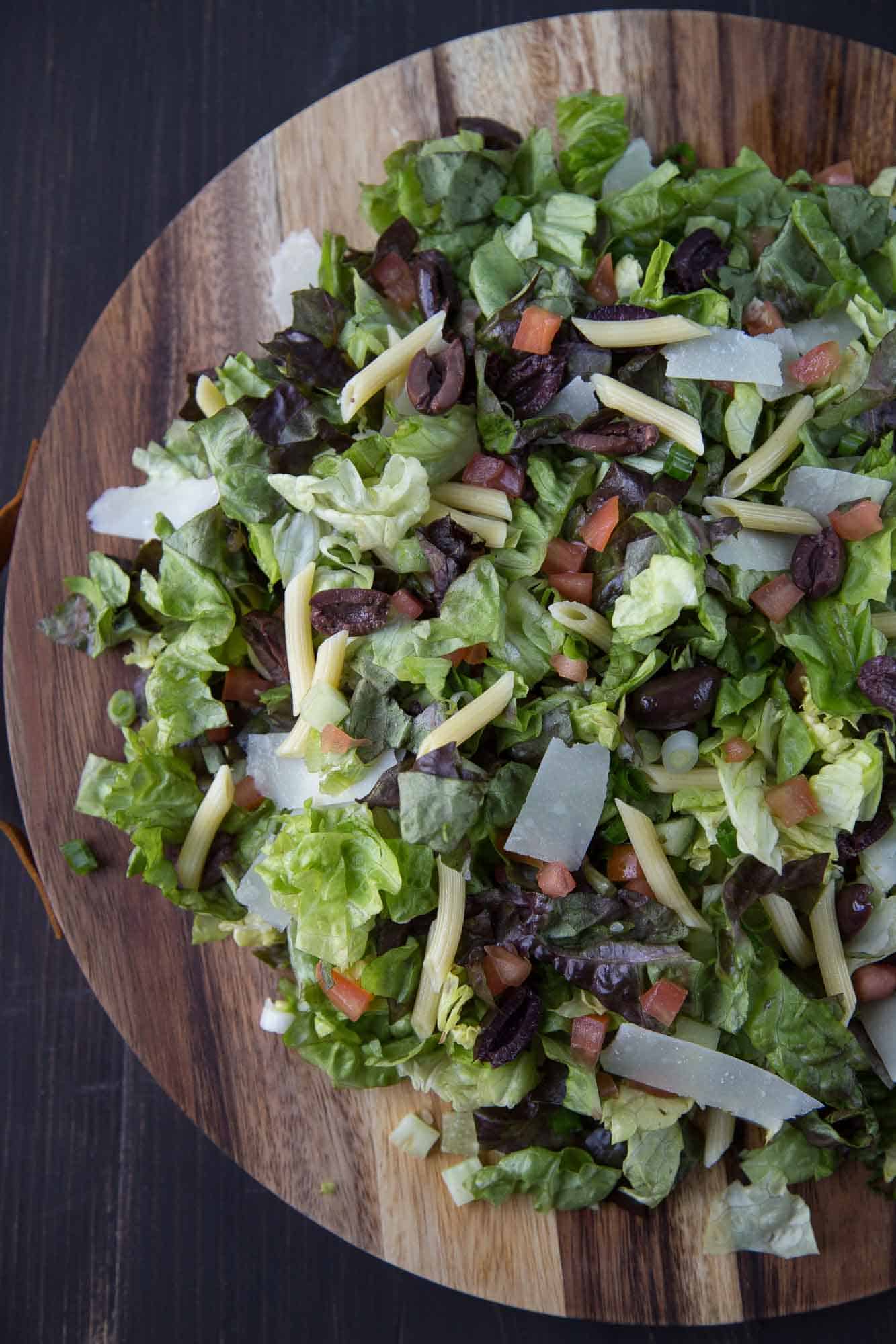 Italian chopped salad on a round wooden platter.