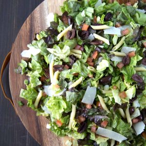 italian chopped salad on a round wooden serving platter.