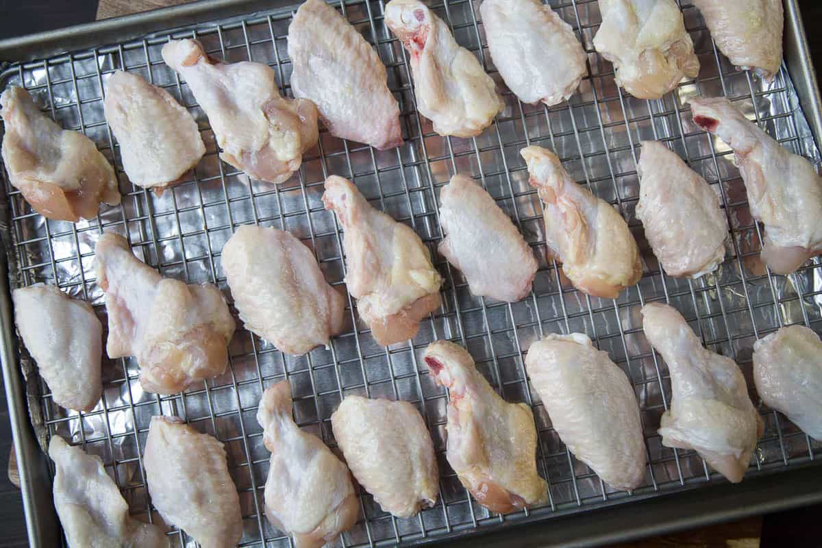 raw chicken wings on a wire rack.