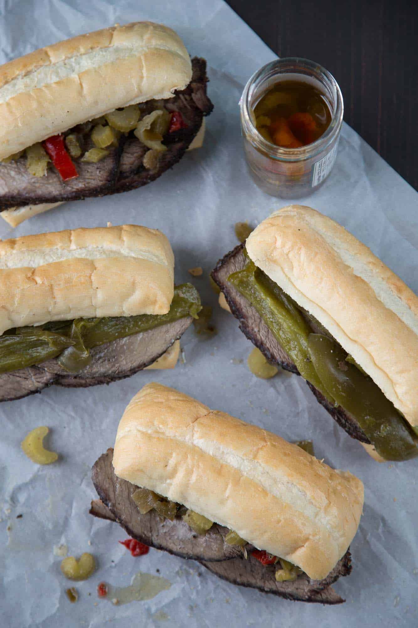 view from the top of slow cooker italian beef sandwiches with giardiniera and sweet peppers on big soft rolls.