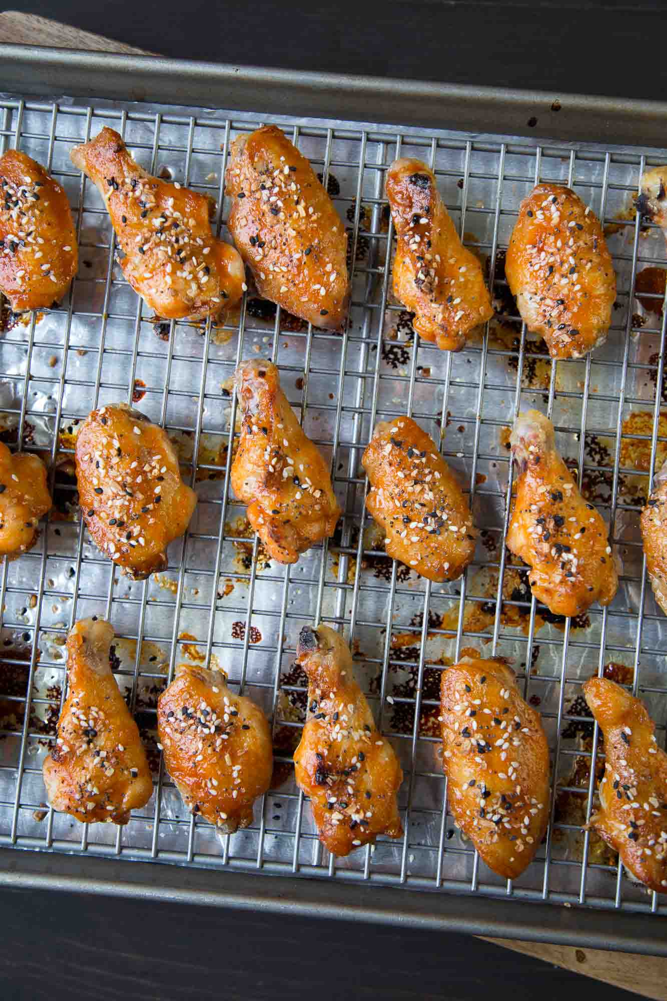 crispy baked wings topped with everything bagel seasoning, sitting on a wire rack.