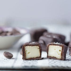 cross section of chocolate covered brie on a white and silver tablecloth.