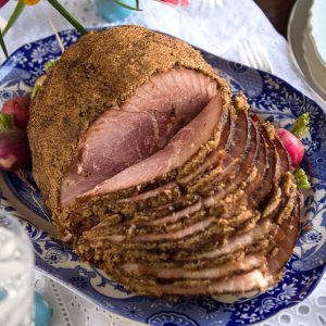 fire glazed ham on a blue and white platter.