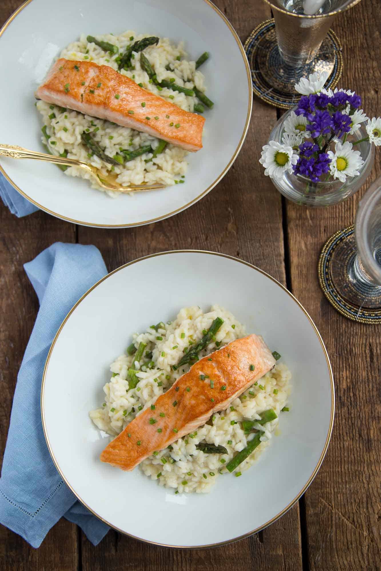 Meyer Lemon and Asparagus Risotto with Seared Salmon on white china on a wooden table.
