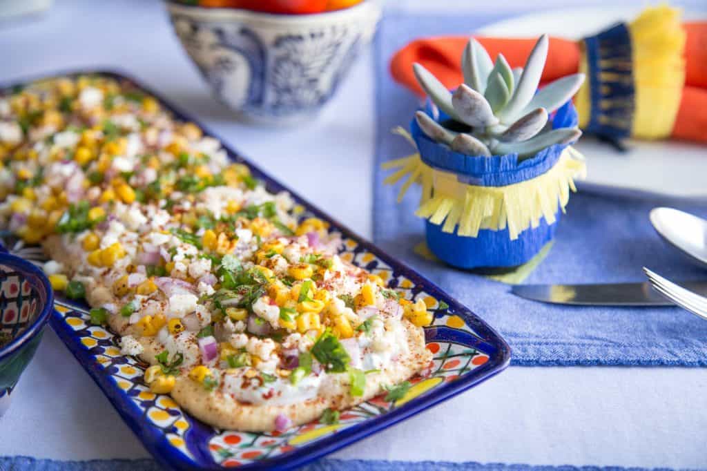 mini succulent next to a platter of mexican street corn dip.