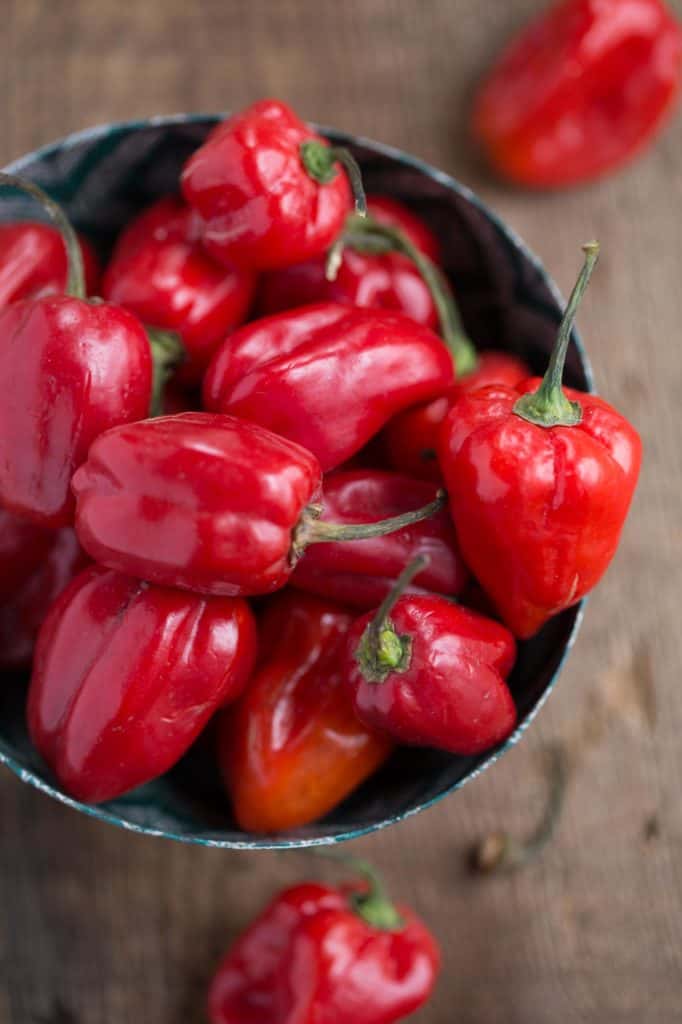 green bowl of scotch bonnet peppers