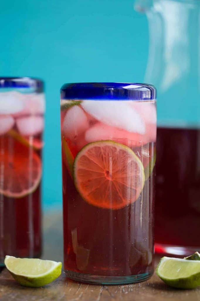 Hibiscus tea in a tall clear glass with a blue rim