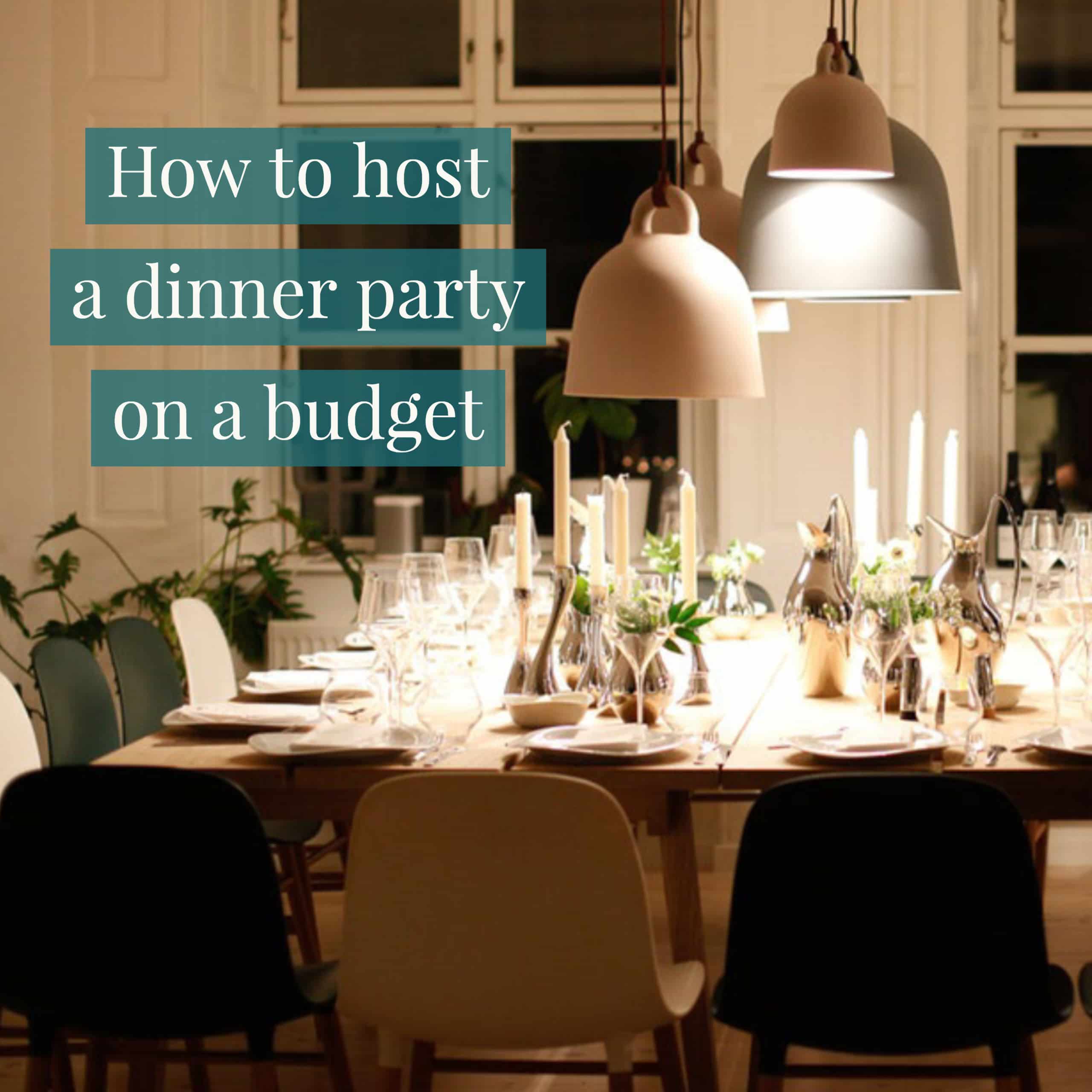 table set with plates, glassware, and taper candles, with pendant lights hanging above the table.
