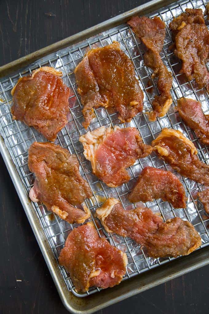 homemade beef jerky uncooked on a wire rack