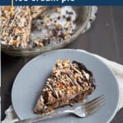 slice of mississippi mud ice cream pie on gray plate next to a whole pie.