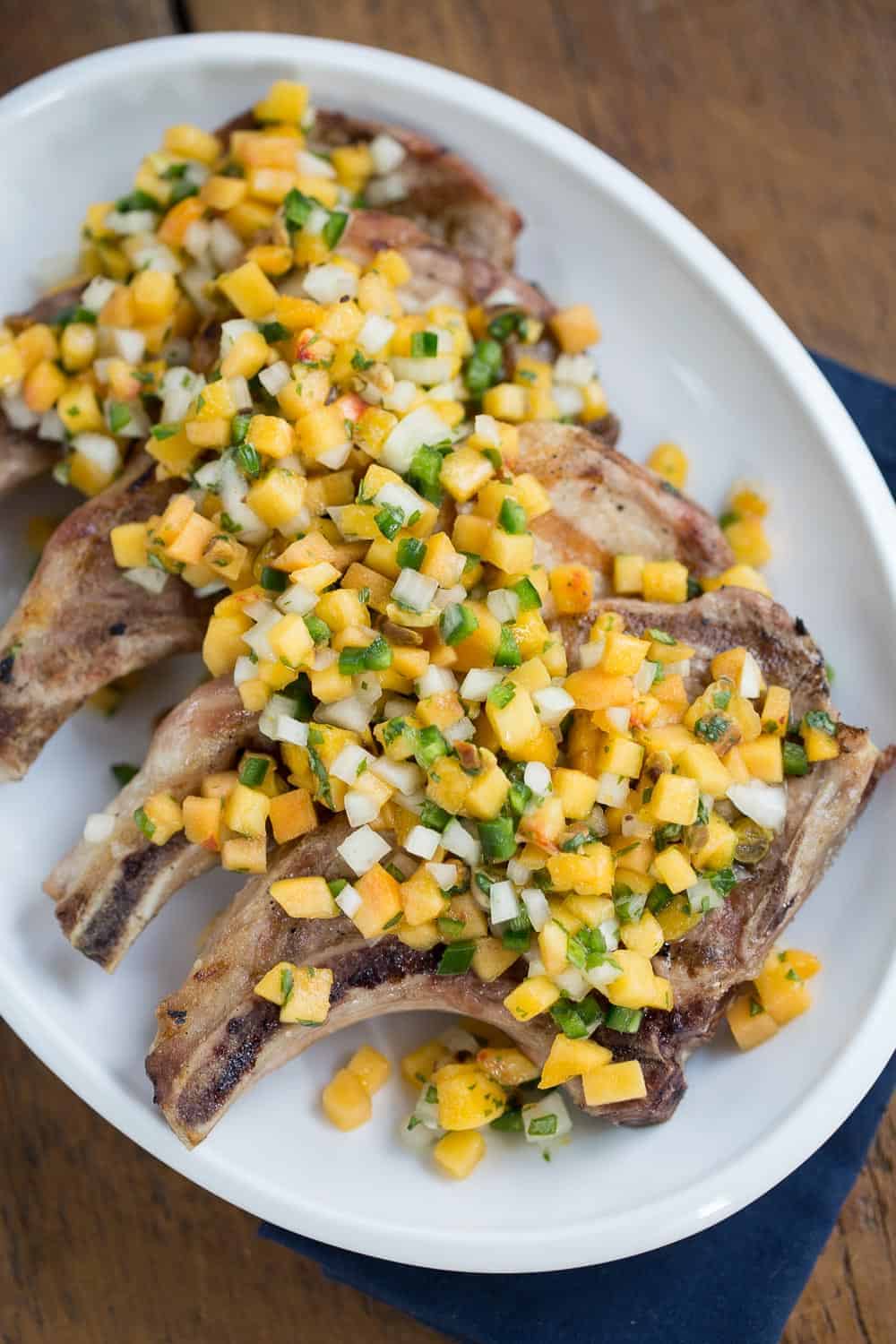 pork chops with peach salsa on a white platter