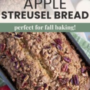 a loaf of apple bread topped with cinnamon streusel and pecans.