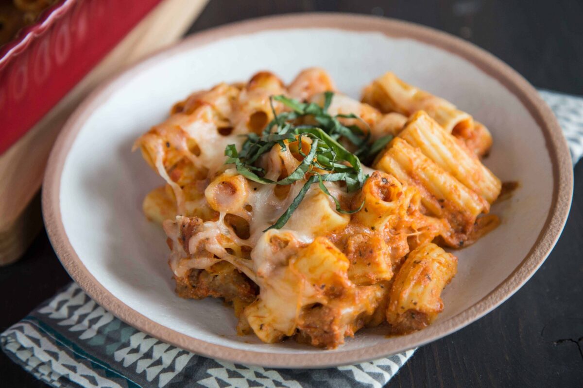 bowl of baked ziti topped with fresh basil.