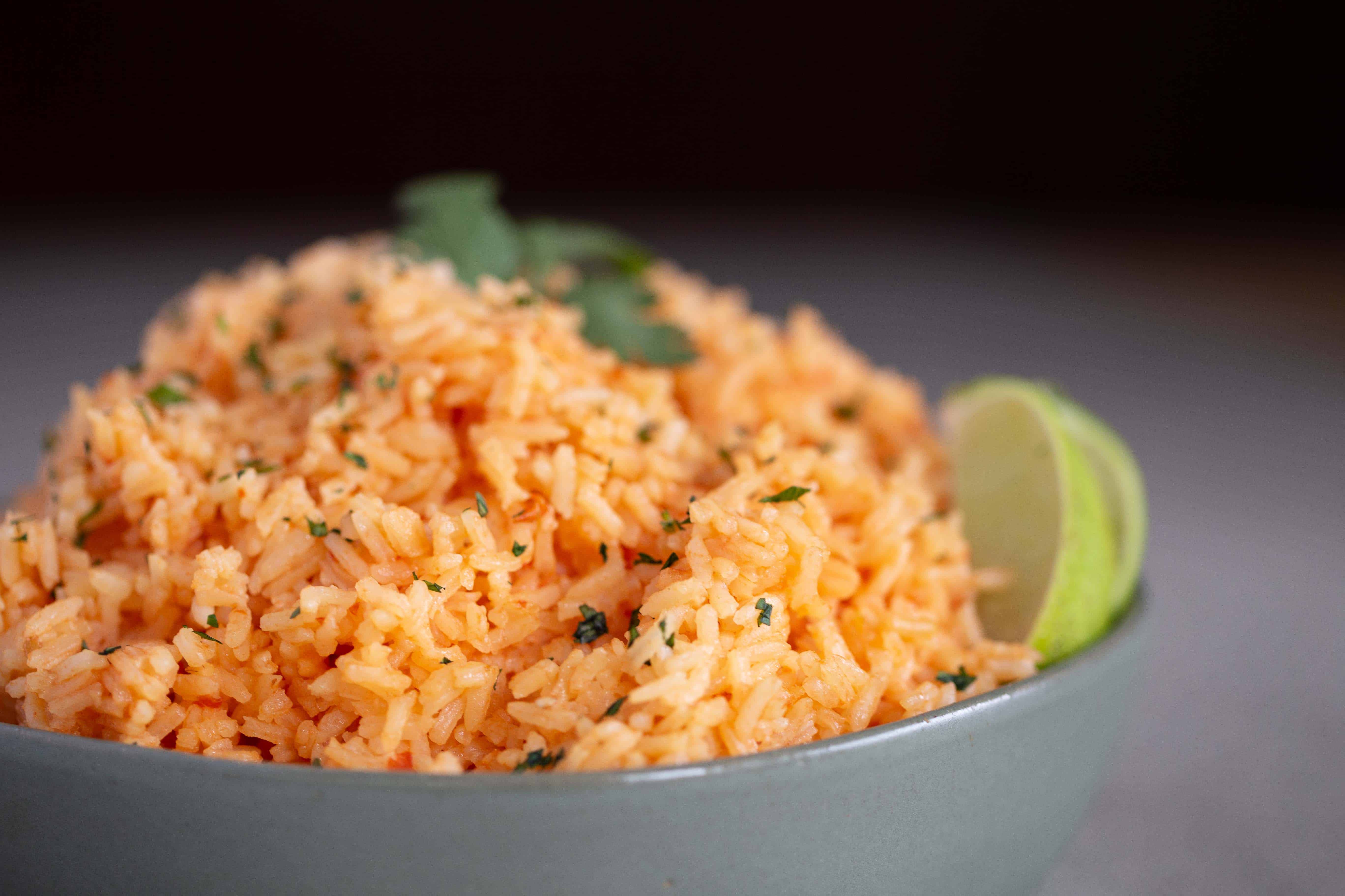 Authentic Mexican Rice with cilantro and lime in a green bowl
