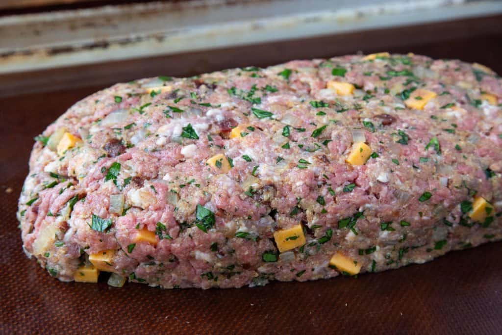 uncooked meatloaf with cubes of cheddar.