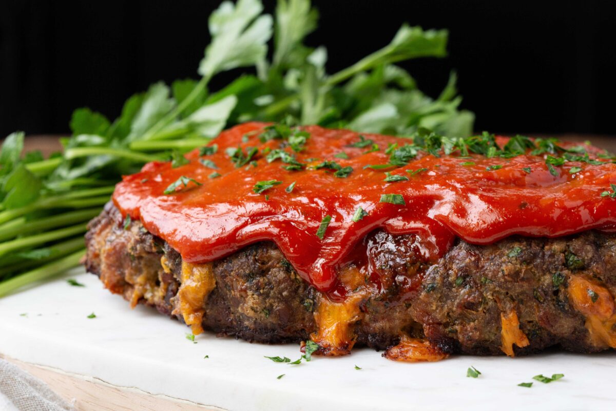 meatloaf with cheddar dripping out, topped with ketchup.