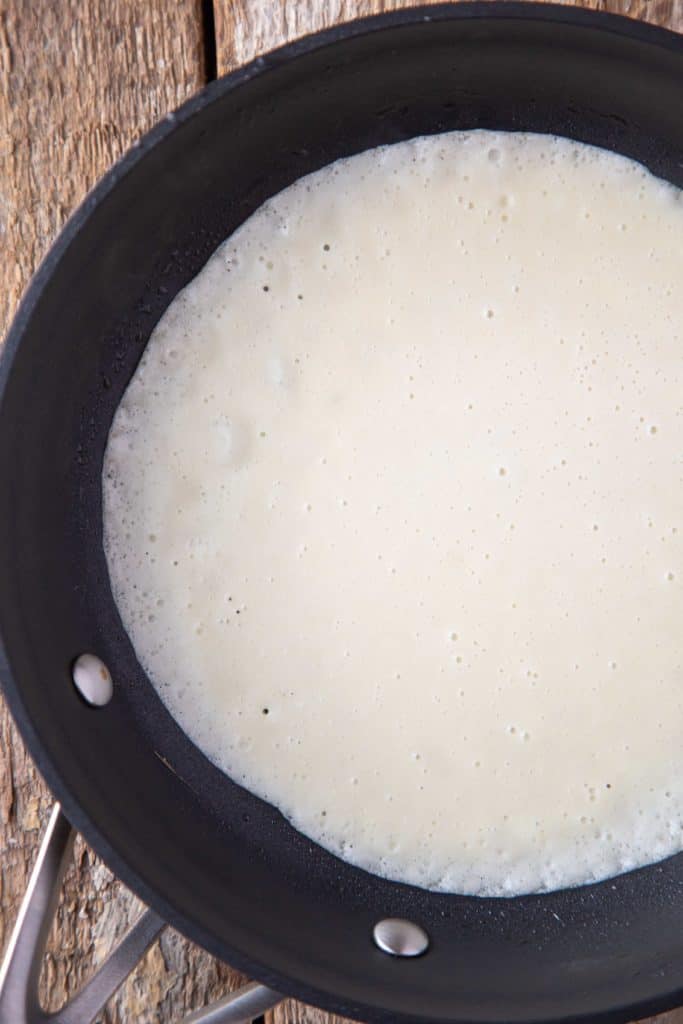 uncooked crepe in a nonstick skillet.