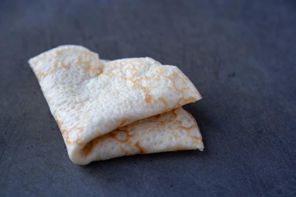 crepe folded in quarters on a cutting board.