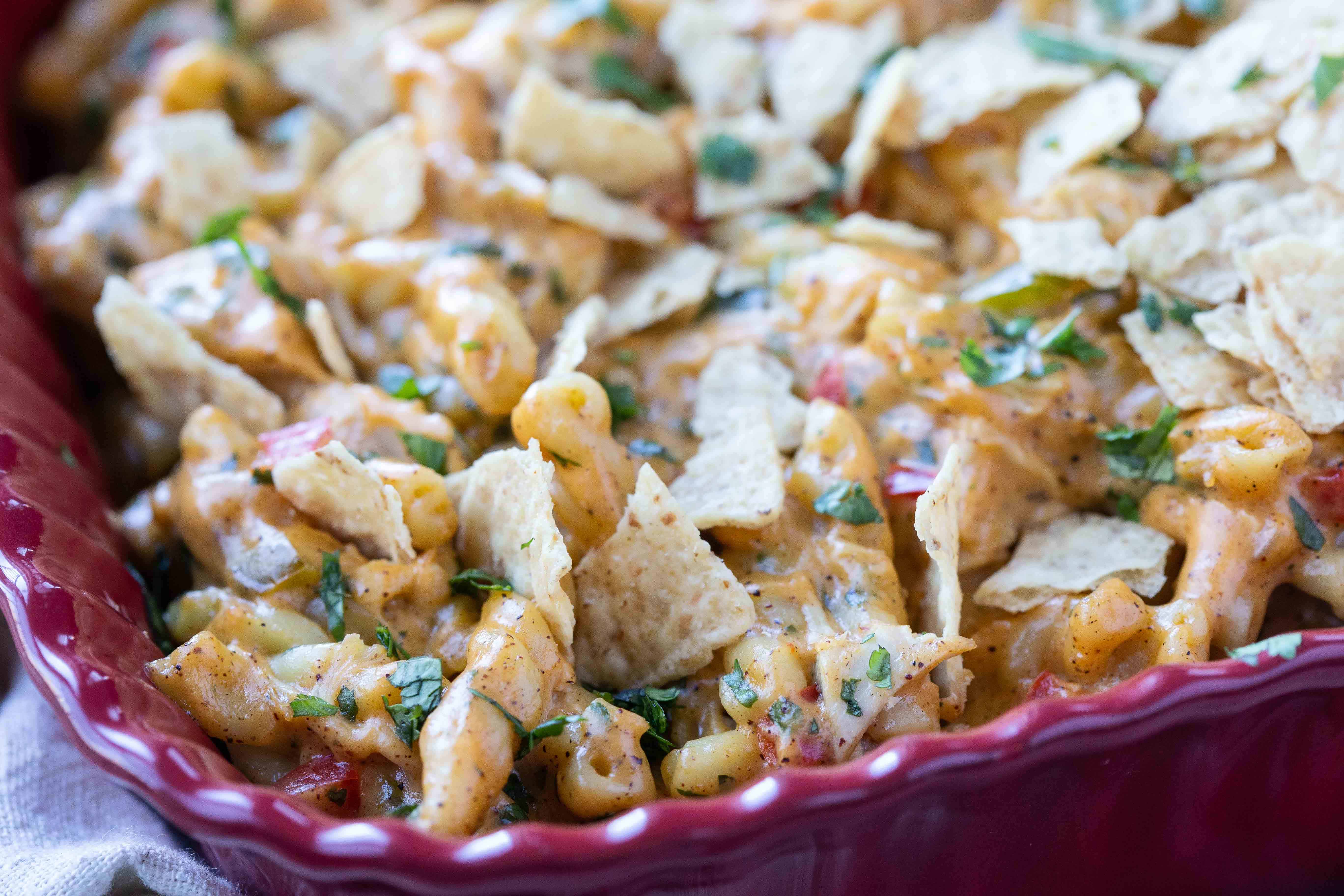 King Ranch Chicken Mac and Cheese in a red casserole dish topped with tortilla chips