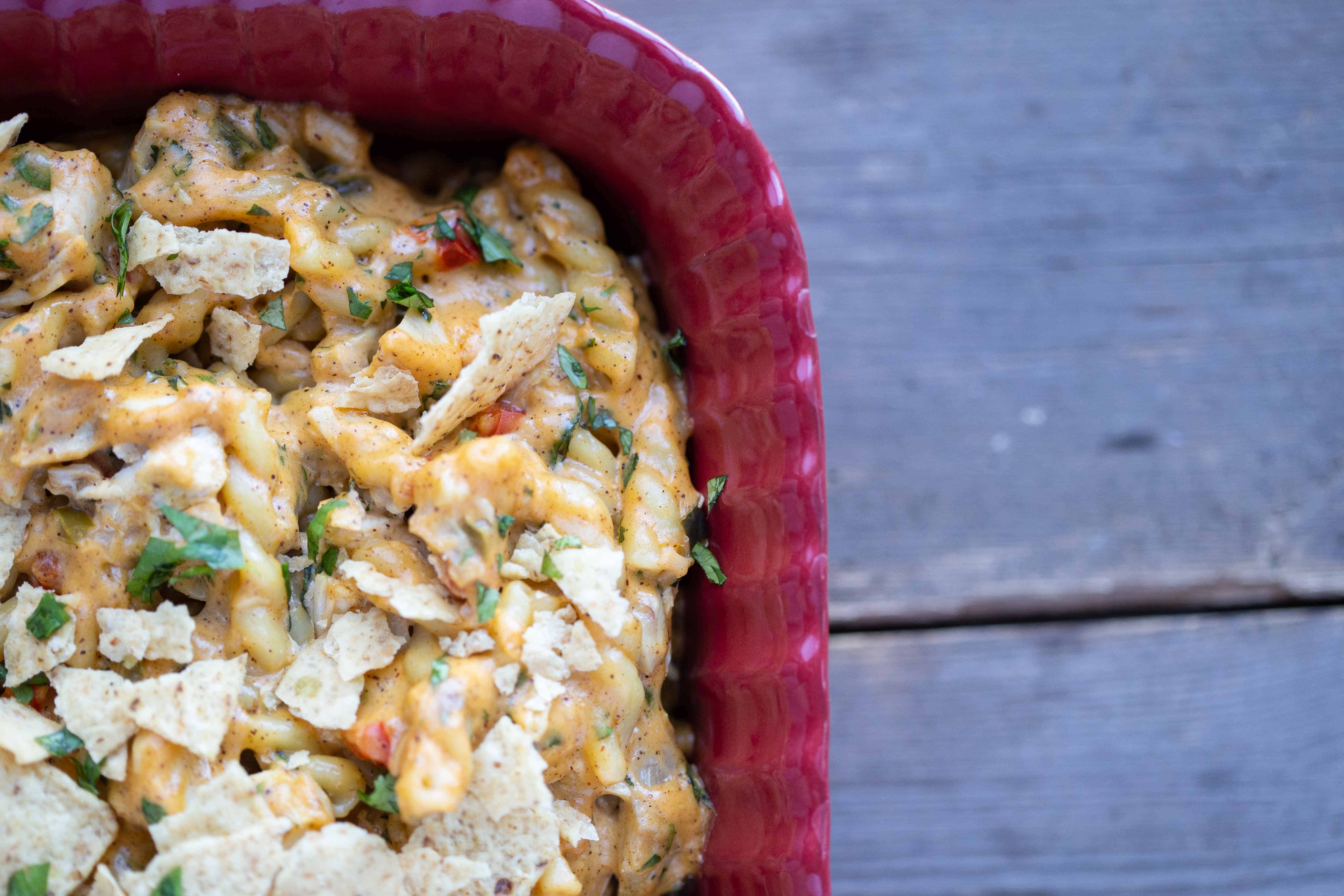 King Ranch Chicken Mac and Cheese in a red casserole dish on a gray wooden table