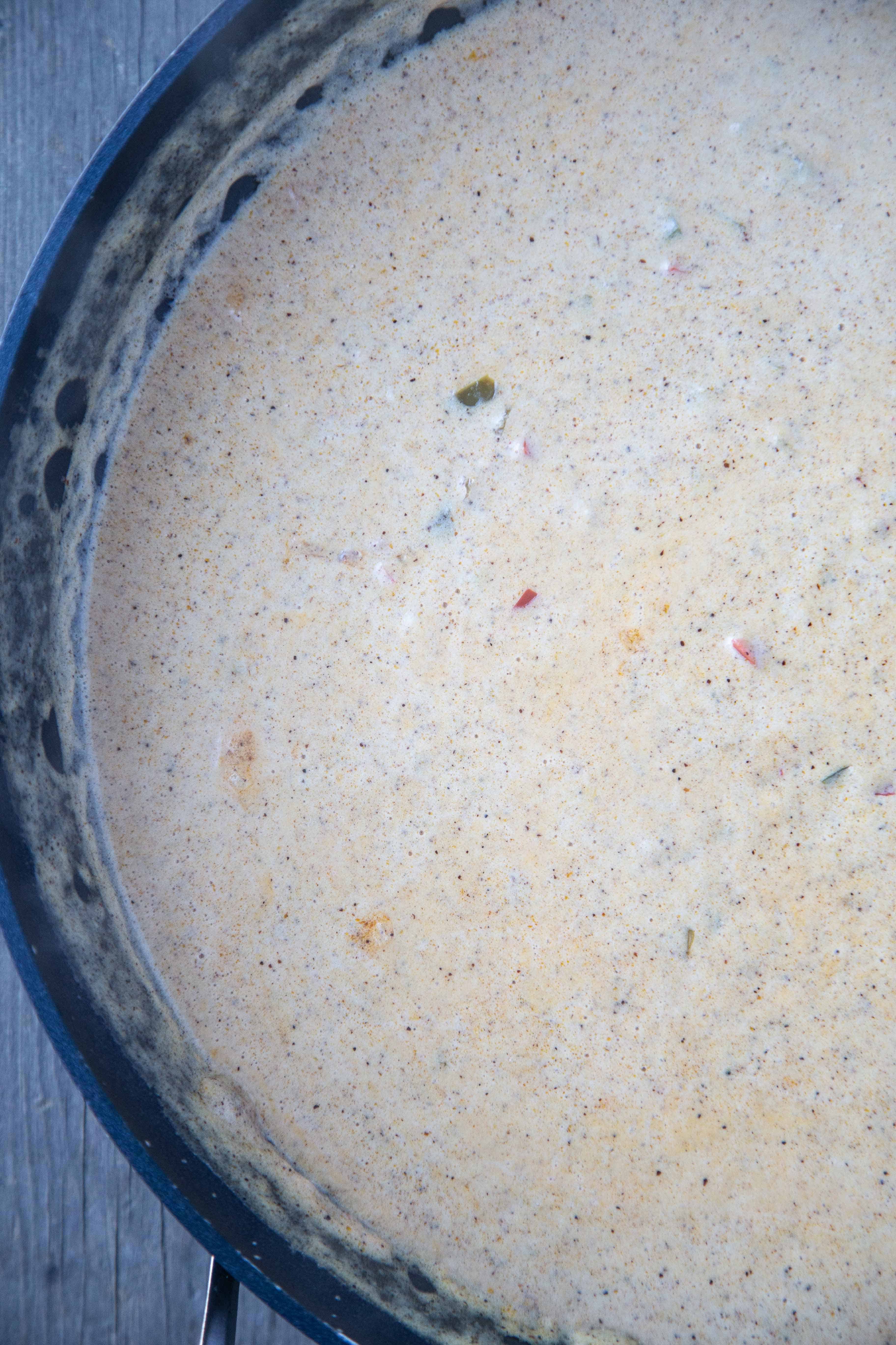 creamy sauce cooking in a sauté pan
