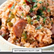 bowl of jambalaya including seasoned rice, half moons of andouille sausage, and pieces of chicken.