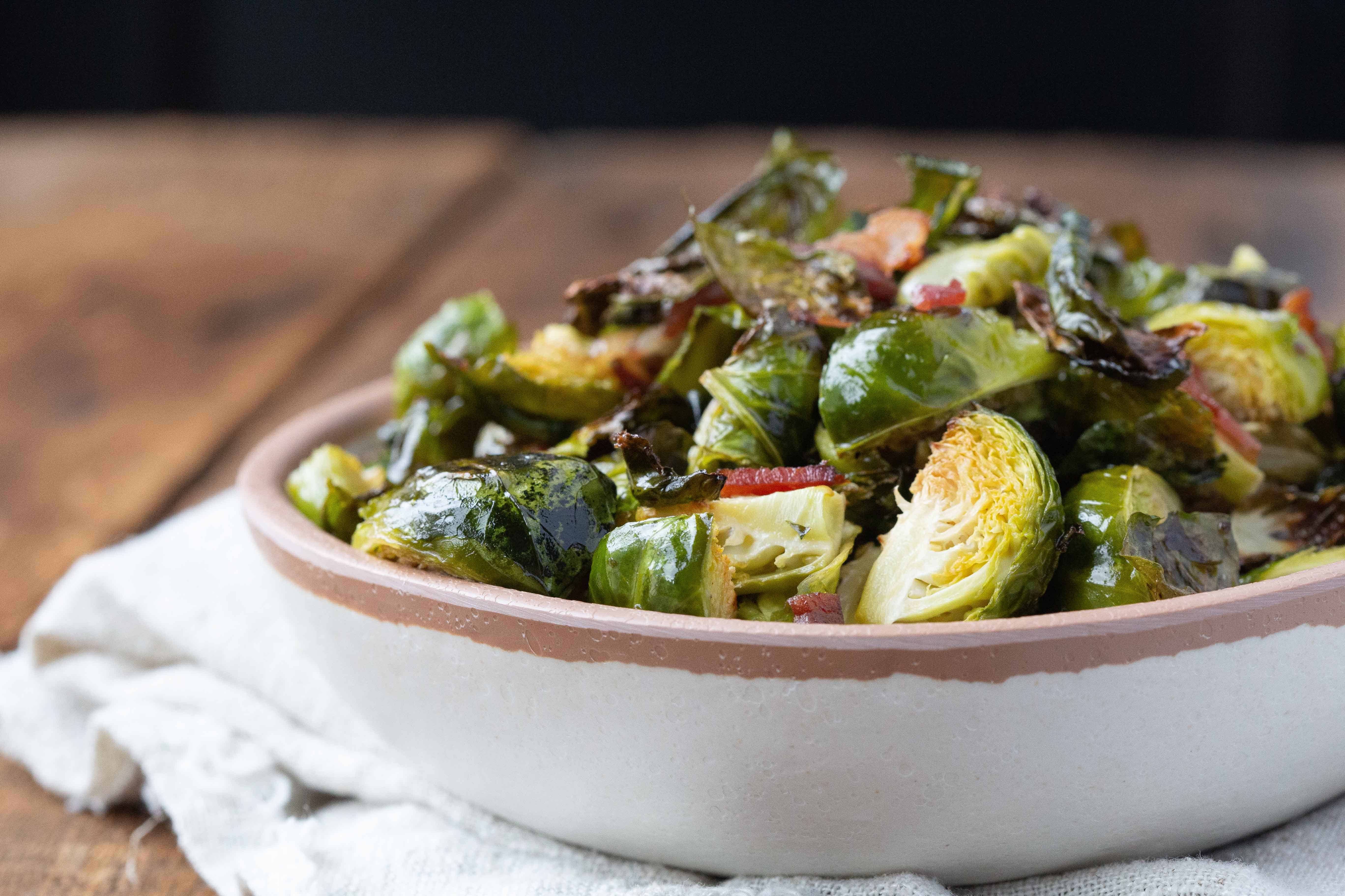 Bacon Brussels Sprouts in a white bowl with a brown rim.