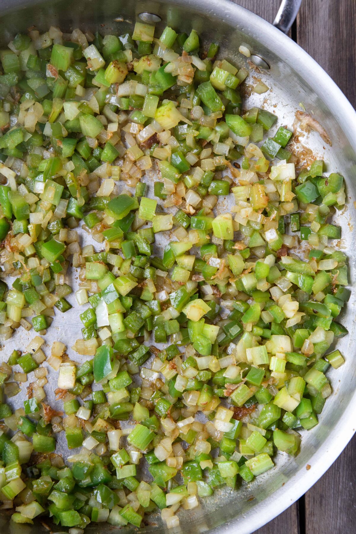 holy trinity of onion, green pepper, and celery sautéing in a large pan.