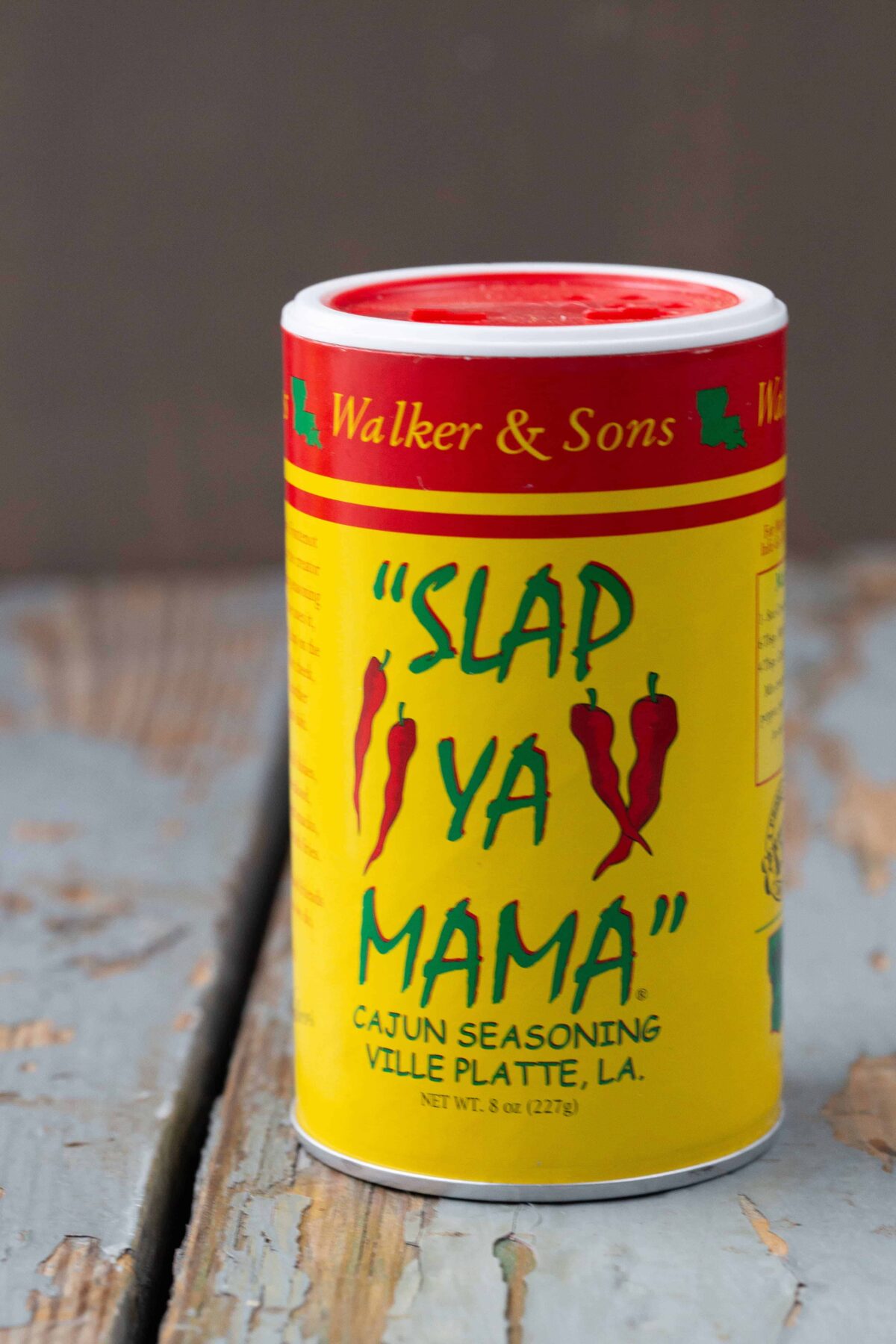 jar of Slap Ya Mama seasoning on a wooden table.