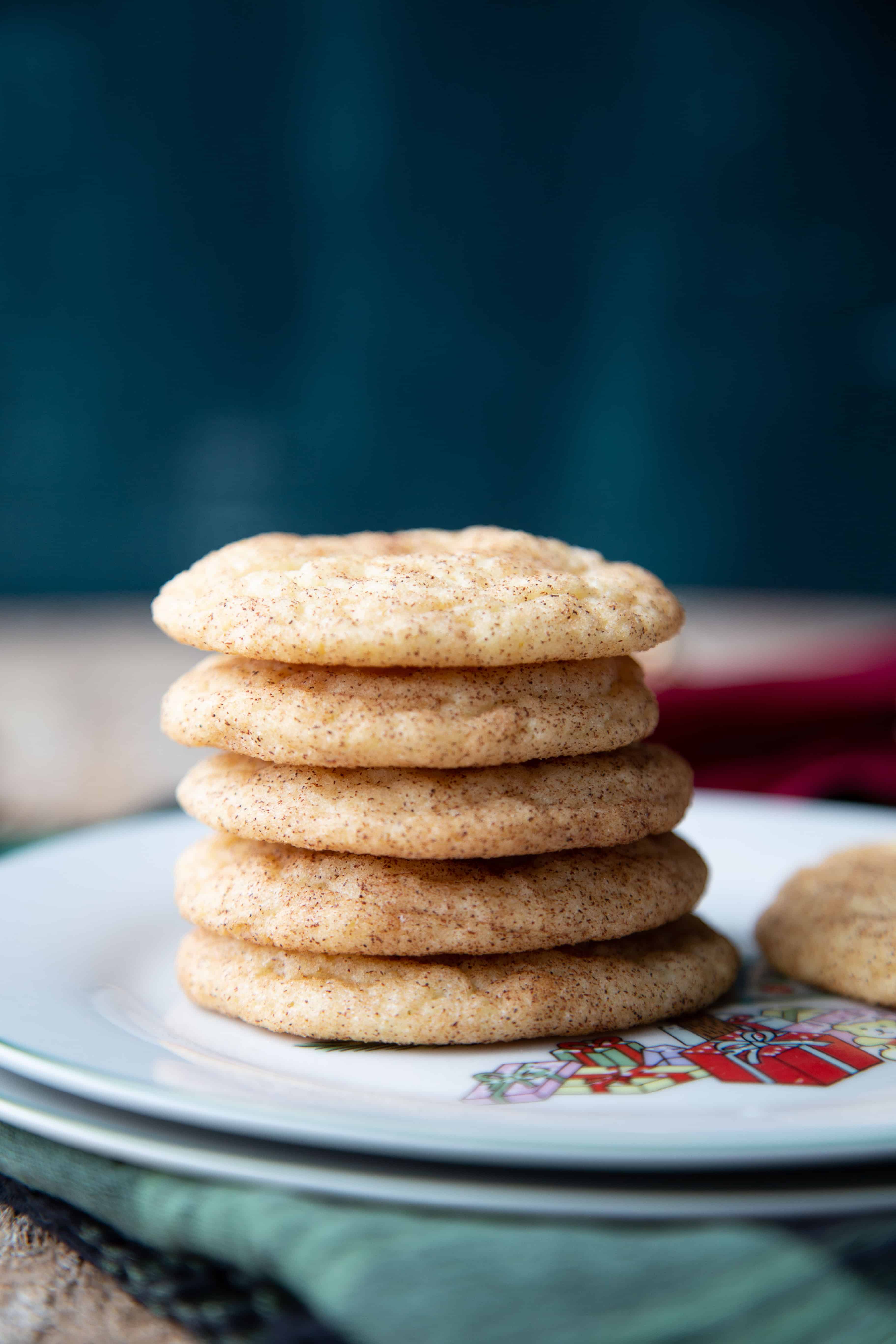Snickerdoodles stacked on a white christmas plate.