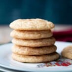 a stack of five snickerdoodle cookies, sitting on a white Christmas plate.