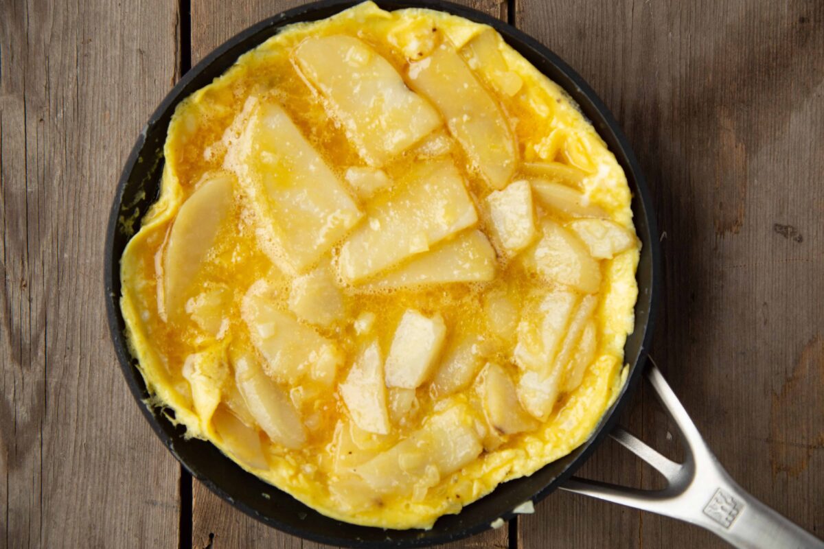 uncooked Tortilla Espanola (Spanish Potato Omelette) in a skillet.